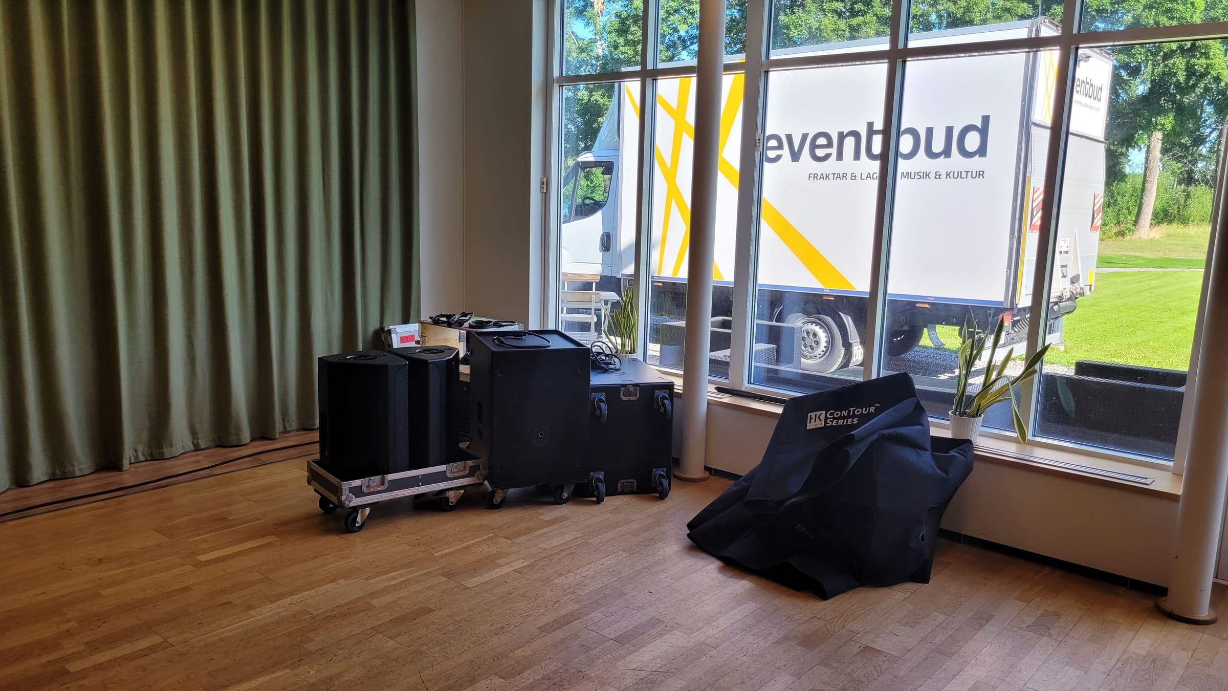 Ljudutrustning och flightcases uppställda i en eventlokal på Vidbynäs