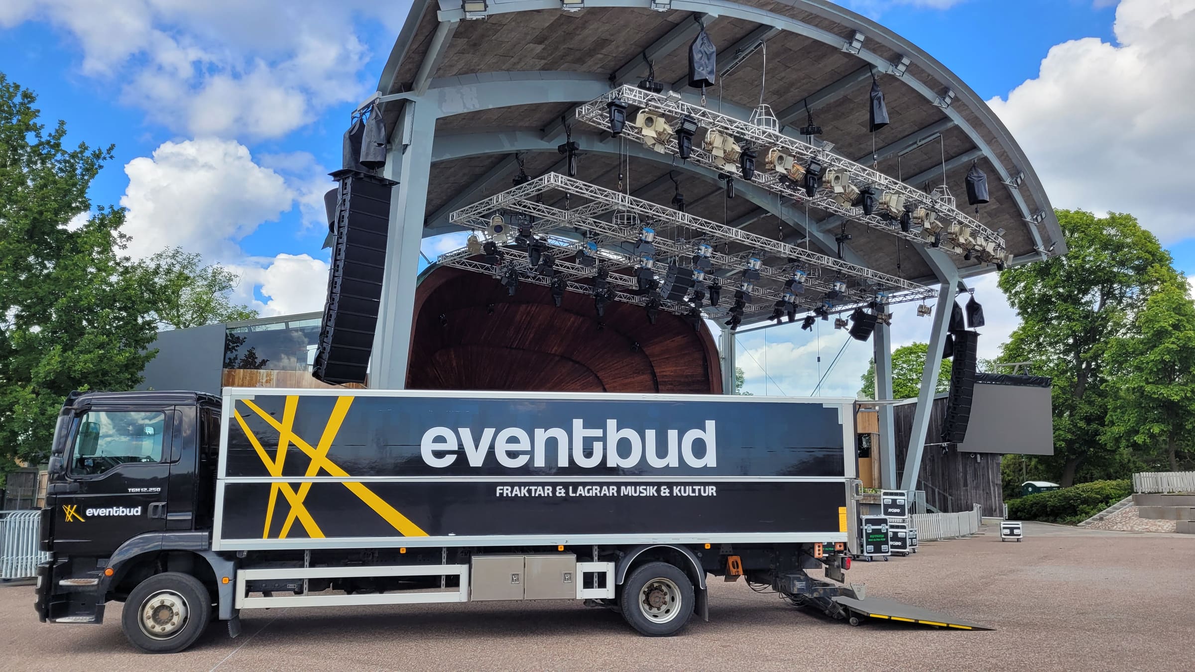 Eventbuds lastbil parkerad vid en utomhusscen med ljusrigg